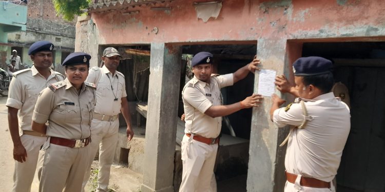 बुलेट अंसारी हत्याकांड के छः आरोपियों के घर पर पुलिस ने चिपकाए इश्तिहार, ढोल ताशे के साथ पहुंची पुलिस